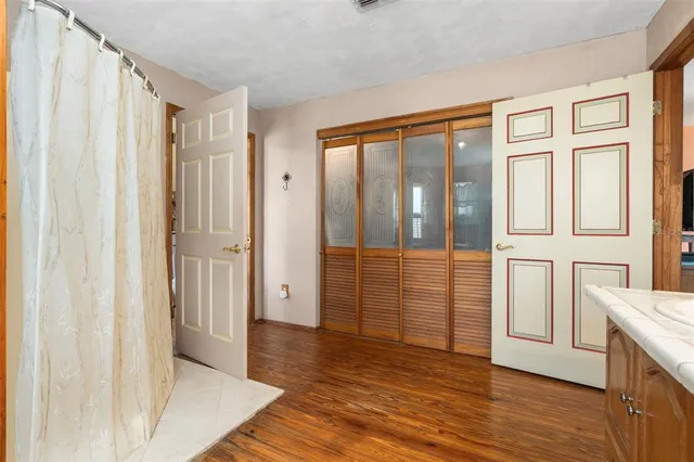 a bedroom with a bed and wooden floor