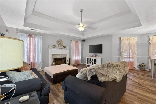 a living room with a bed furniture a flat screen tv and a fireplace