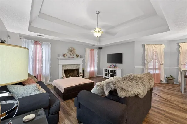 a living room with a bed furniture a flat screen tv and a fireplace