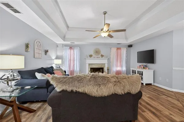 a living room with furniture a flat screen tv and a fireplace