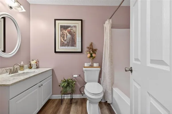 a bathroom with a toilet a sink a mirror a vanity and window