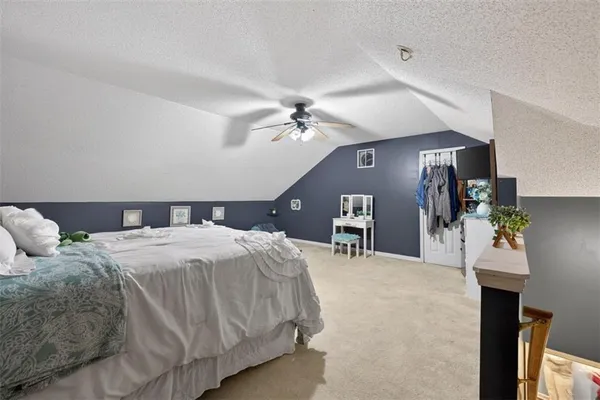 a spacious bedroom with a bed and a chandelier