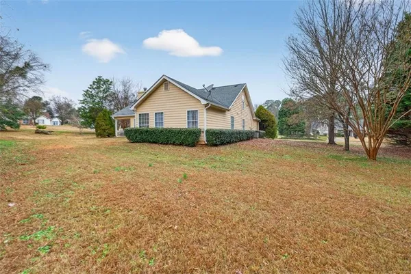 a view of an house with backyard and trees