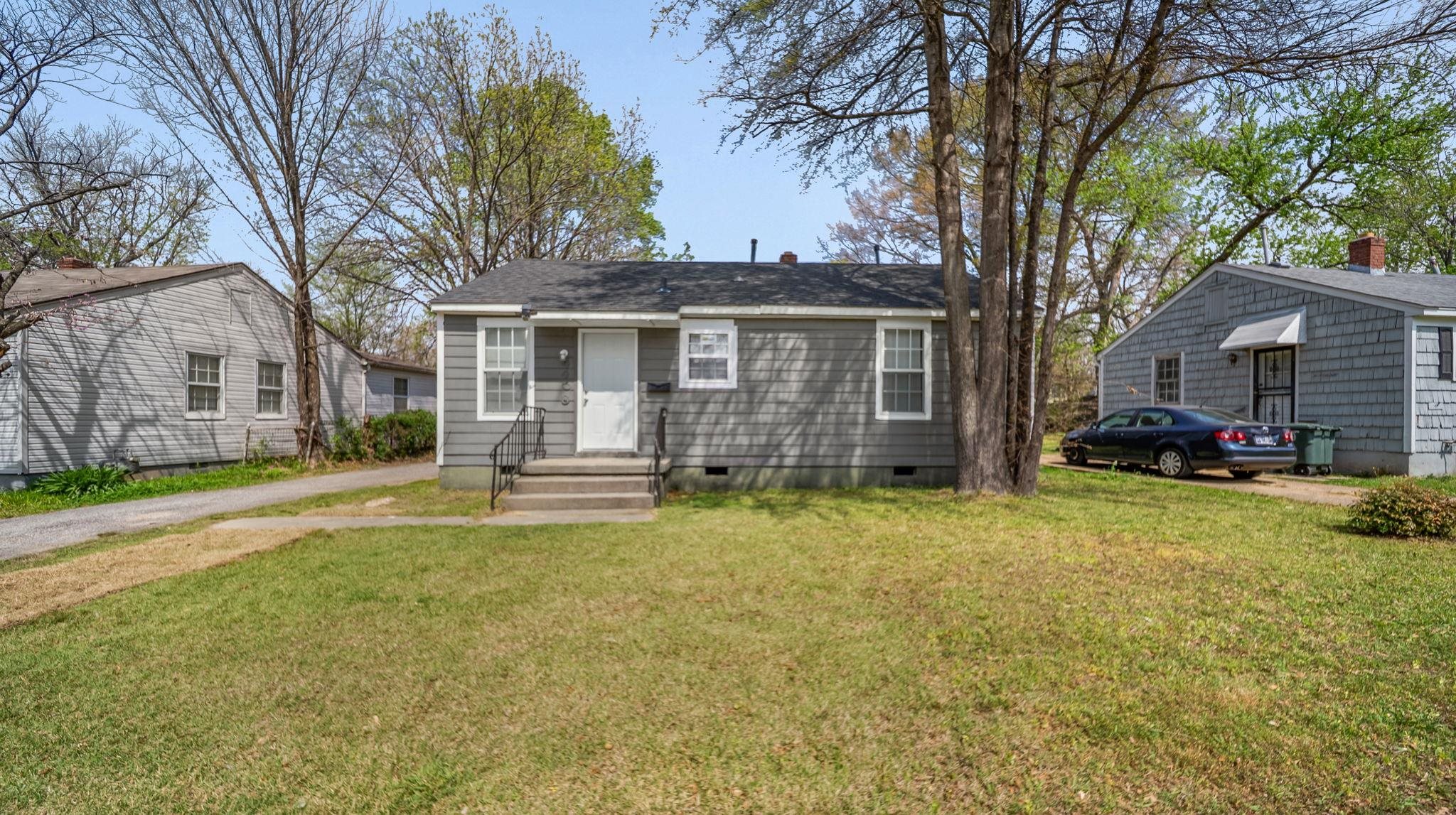 a view of a house with a yard covered with trees