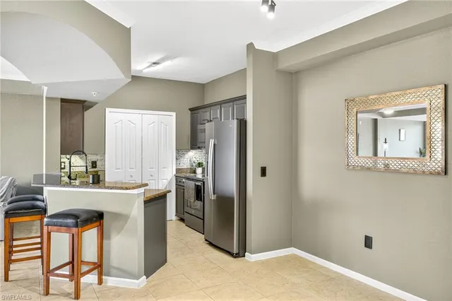 a kitchen with stainless steel appliances granite countertop a refrigerator a stove and a sink
