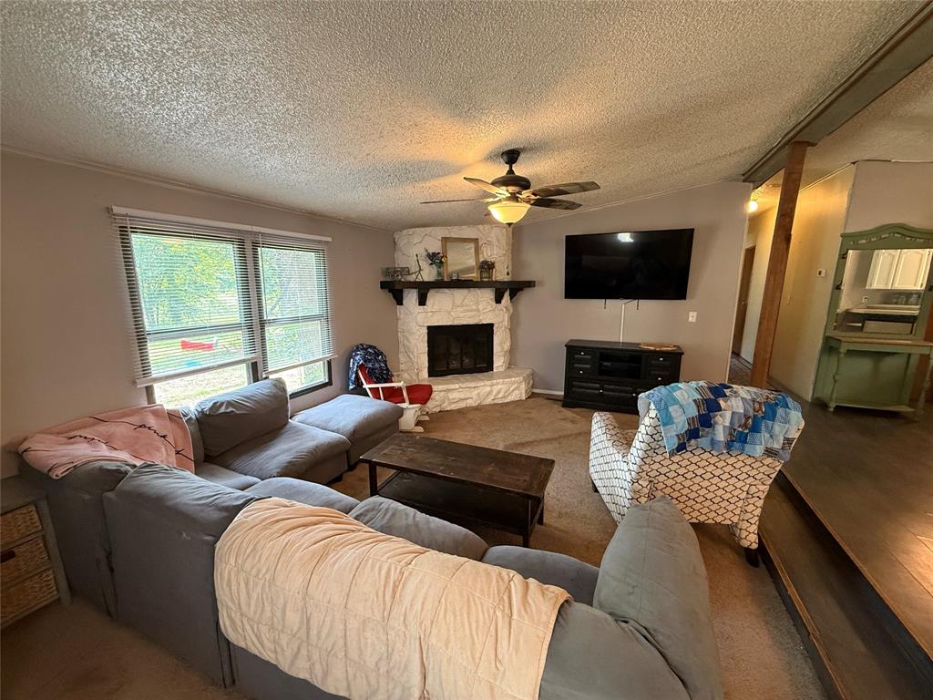 148 Indian Gap Road Mabank, TX 75156 - Photo 11 of 23 a living room with furniture a fireplace and a flat screen tv