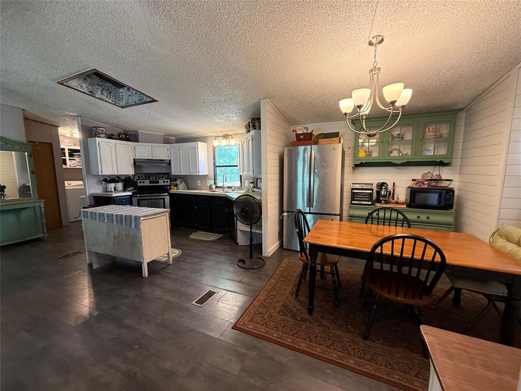 148 Indian Gap Road Mabank, TX 75156 - Photo 7 of 23 a kitchen with stainless steel appliances granite countertop a stove refrigerator and couches with wooden floor