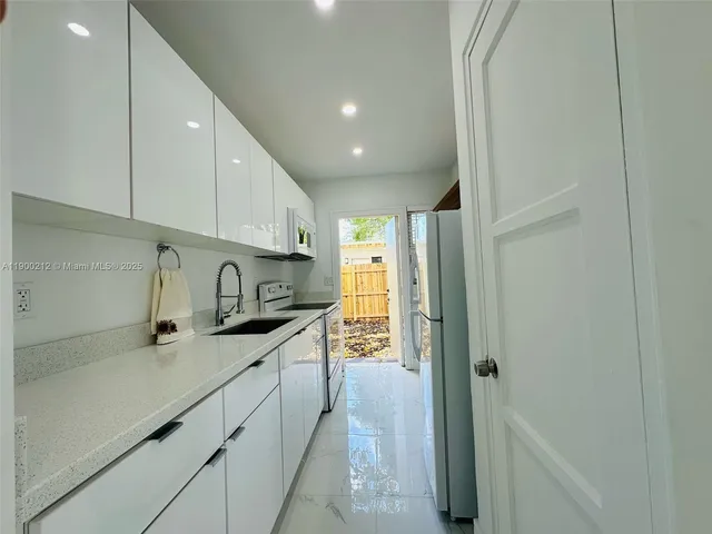 a kitchen with stainless steel appliances granite countertop a sink and cabinets
