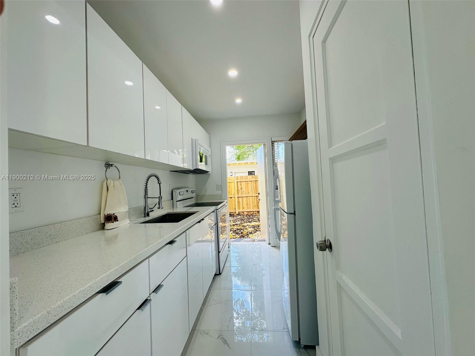 407 Southeast 14th Court, Unit 2 Fort Lauderdale, FL 33316 - Photo 4 of 16 a kitchen with stainless steel appliances granite countertop a sink and cabinets
