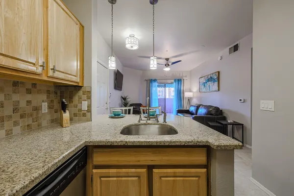 a kitchen with granite countertop a sink a counter space and cabinets