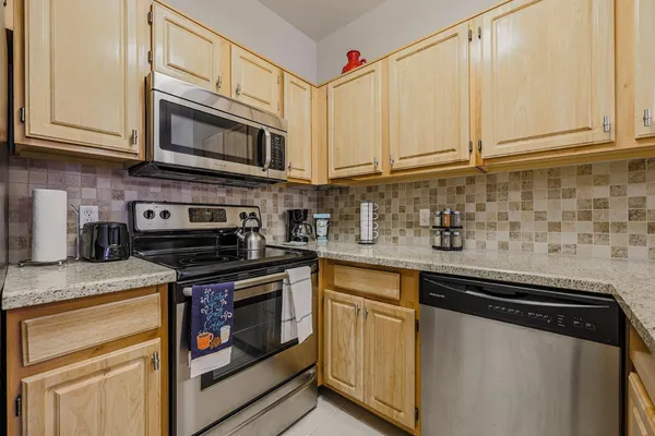 a kitchen with stainless steel appliances granite countertop a stove a microwave and cabinets