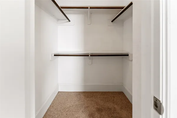 an empty room with closet and windows