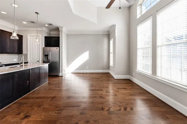 a kitchen with kitchen island stainless steel appliances a sink cabinets and wooden floor
