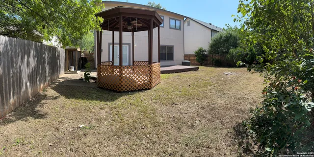 a view of a backyard with table and chairs under an umbrella