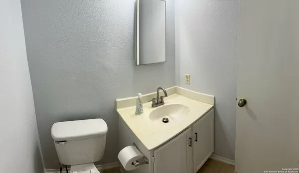 a bathroom with a sink mirror and toilet