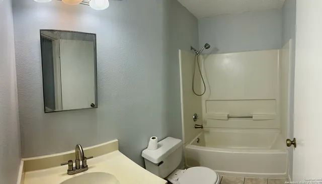 a bathroom with a toilet sink and shower