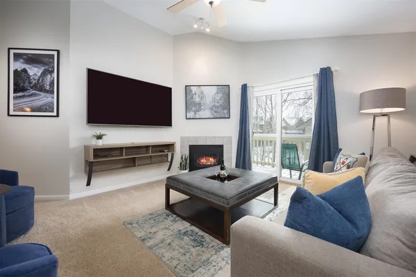 a living room with furniture a flat screen tv and a fireplace