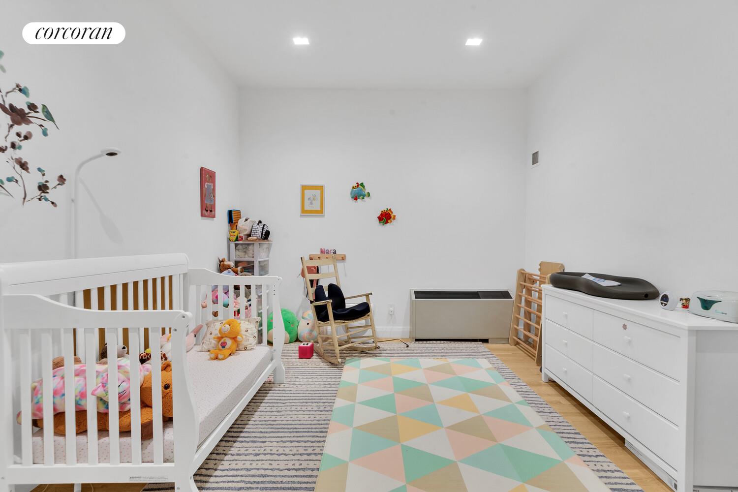 252 7th Avenue, Unit 16J Manhattan, NY 10001 - Photo 6 of 8 a bedroom with furniture and baby crib