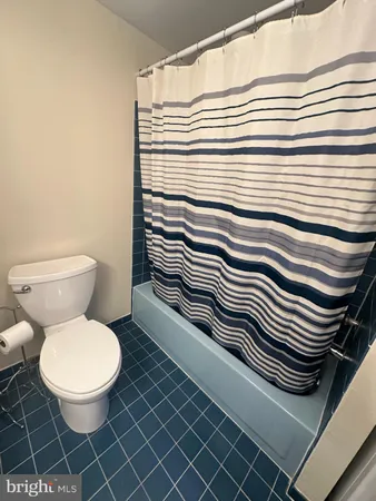 a bathroom with a sink a toilet and a shower curtain