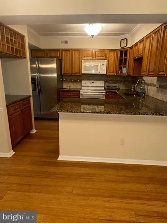 a view of a kitchen with stainless steel appliances granite countertop a refrigerator and a sink