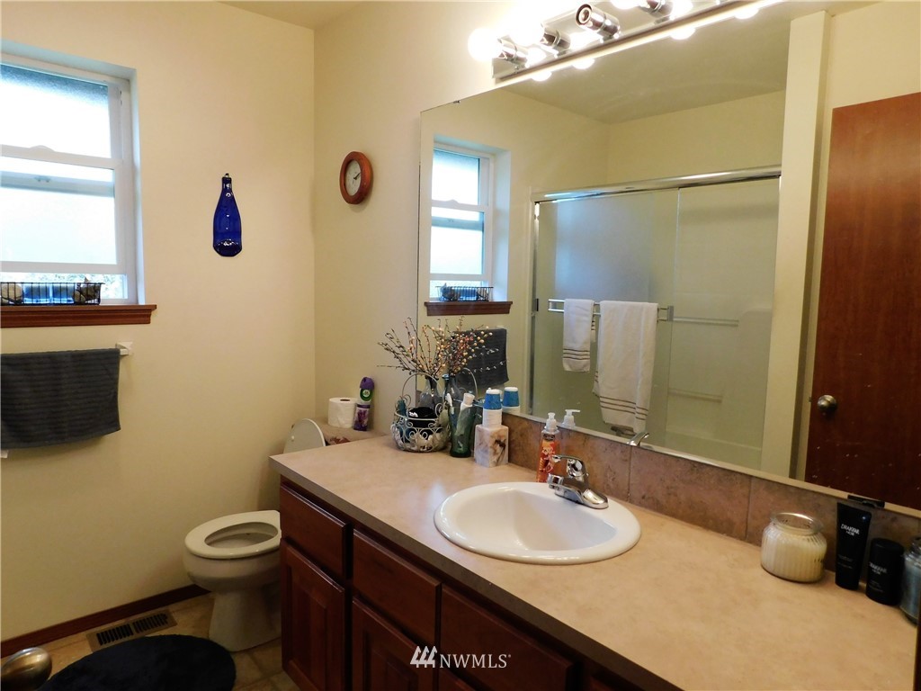 11113 South Lake Stevens Road Lake Stevens, WA 98258 - Photo 8 of 10 a bathroom with a granite countertop toilet sink and mirror
