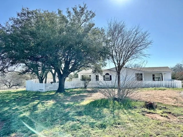 a front view of house with yard and trees