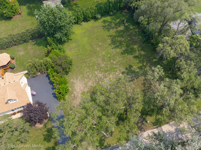 an aerial view of a house with a yard and lake view