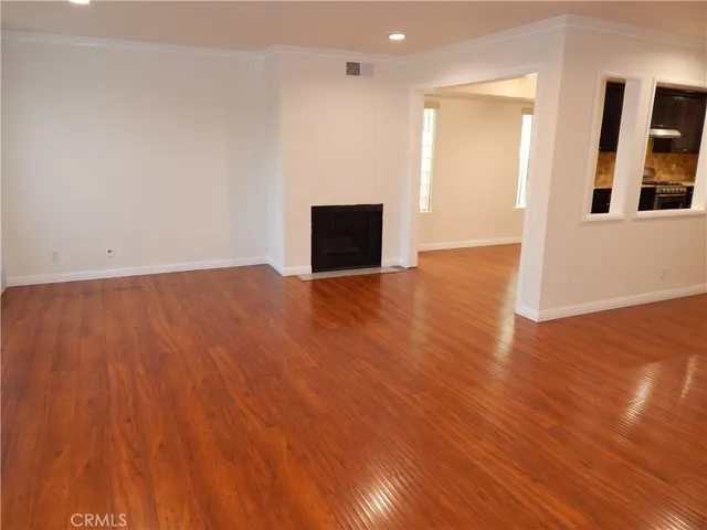 a view of an empty room with wooden floor