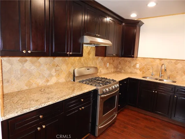 a kitchen with granite countertop wooden cabinets and stainless steel appliances