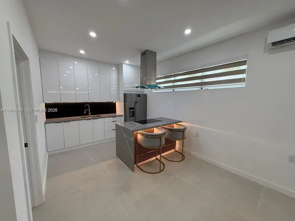 a room with a chair and white cabinets
