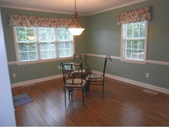 639 Wendy Graham, NC 27253 - Photo 3 of 21 a dining room with wooden floor a chandelier a glass table and chairs