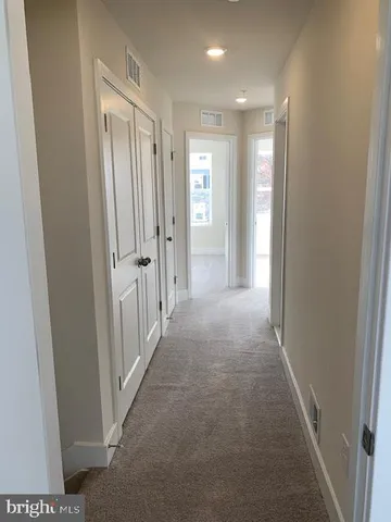 a view of a hallway with wooden shelves