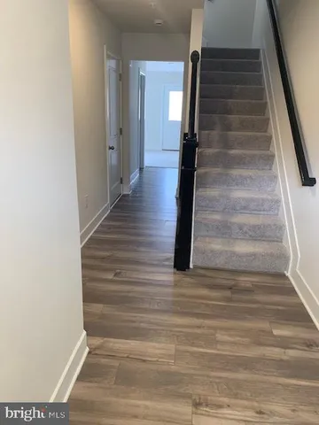 a view of entryway and hall with wooden floor