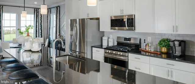 a kitchen with stainless steel appliances a stove a refrigerator a sink a stove and cabinets