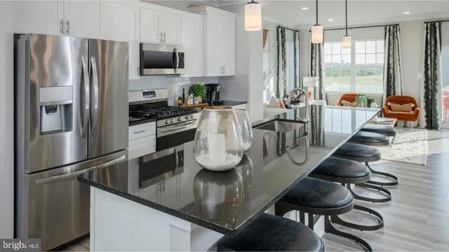 a kitchen with stainless steel appliances granite countertop a sink a stove and a refrigerator