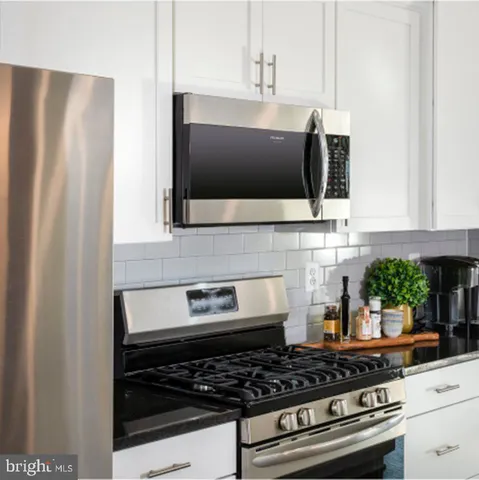 a kitchen with stainless steel appliances granite countertop a stove and a microwave