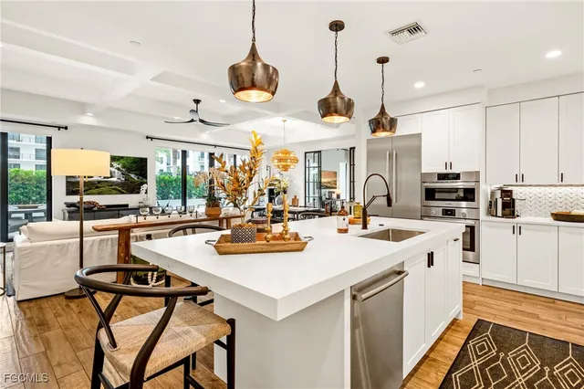 a kitchen with stainless steel appliances a stove a sink and a refrigerator
