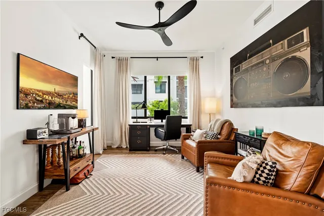 a living room with furniture a flat screen tv and a window