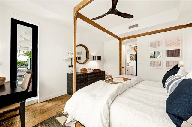 a bedroom with a bed a mirror and paintings on the wall