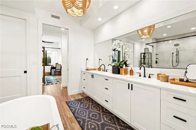 a spacious en suite bathroom with a double vanity sink and a mirror