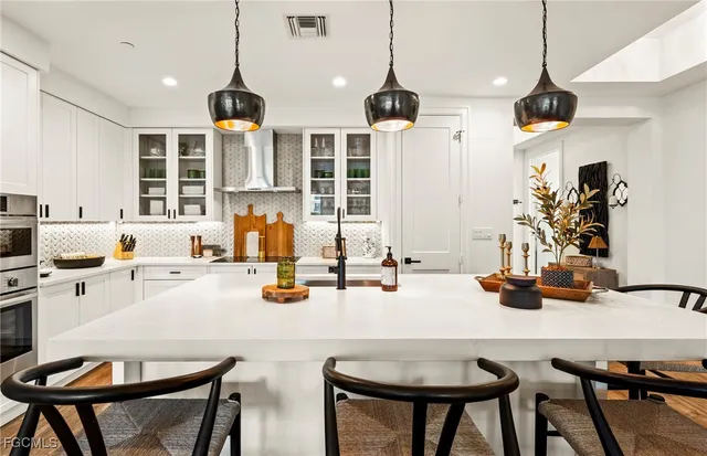 a kitchen with a dining table chairs and white cabinets