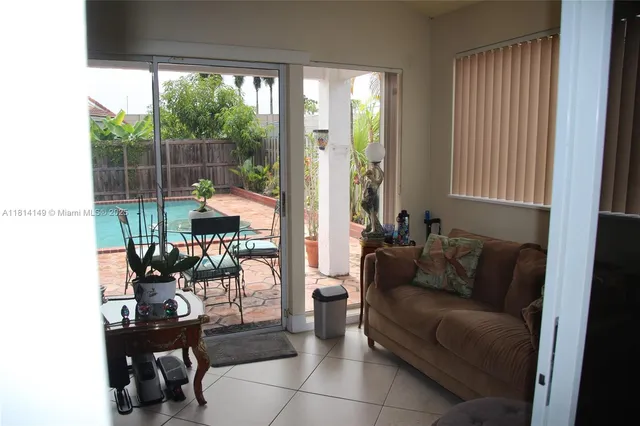 a living room with furniture and a floor to ceiling window