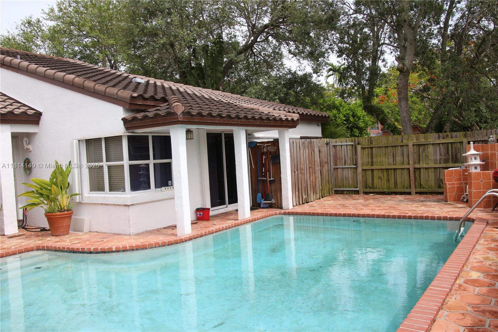11861 Southwest 92nd Lane Miami, FL 33186 - Photo 23 of 33 a view of a backyard with table and chairs potted plants and large tree