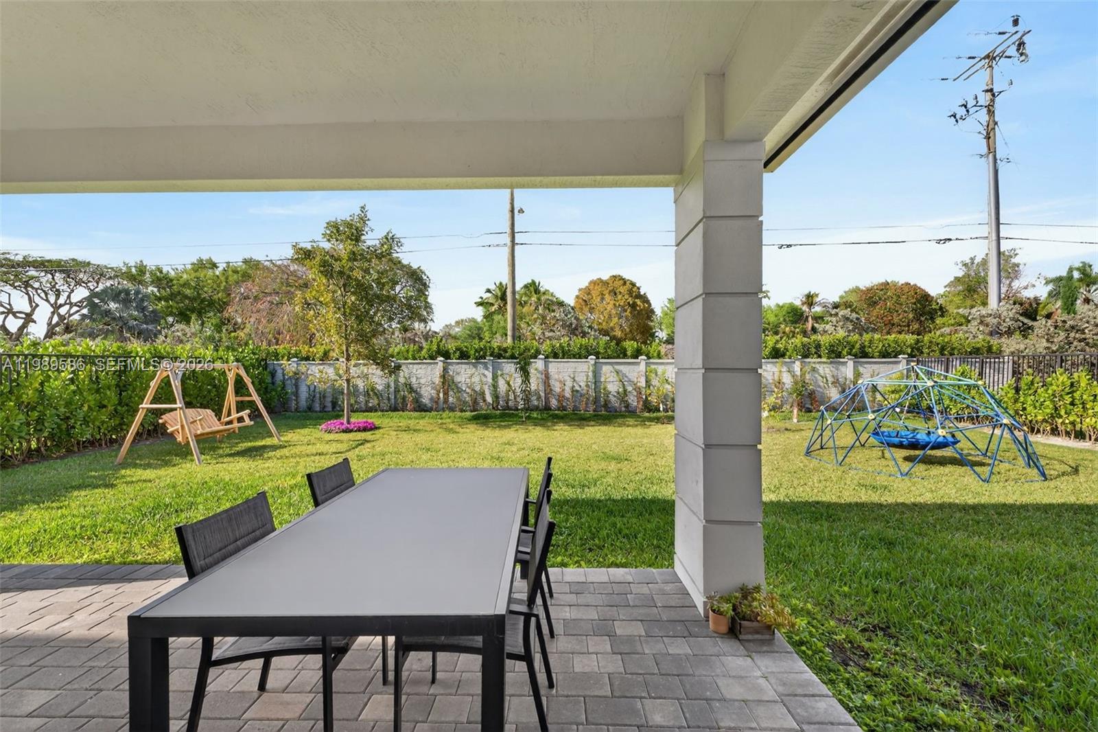 8267 Southwest 120th Terrace Miami, FL 33156 - Photo 41 of 61 a view of a patio with table and chairs potted plants with palm trees