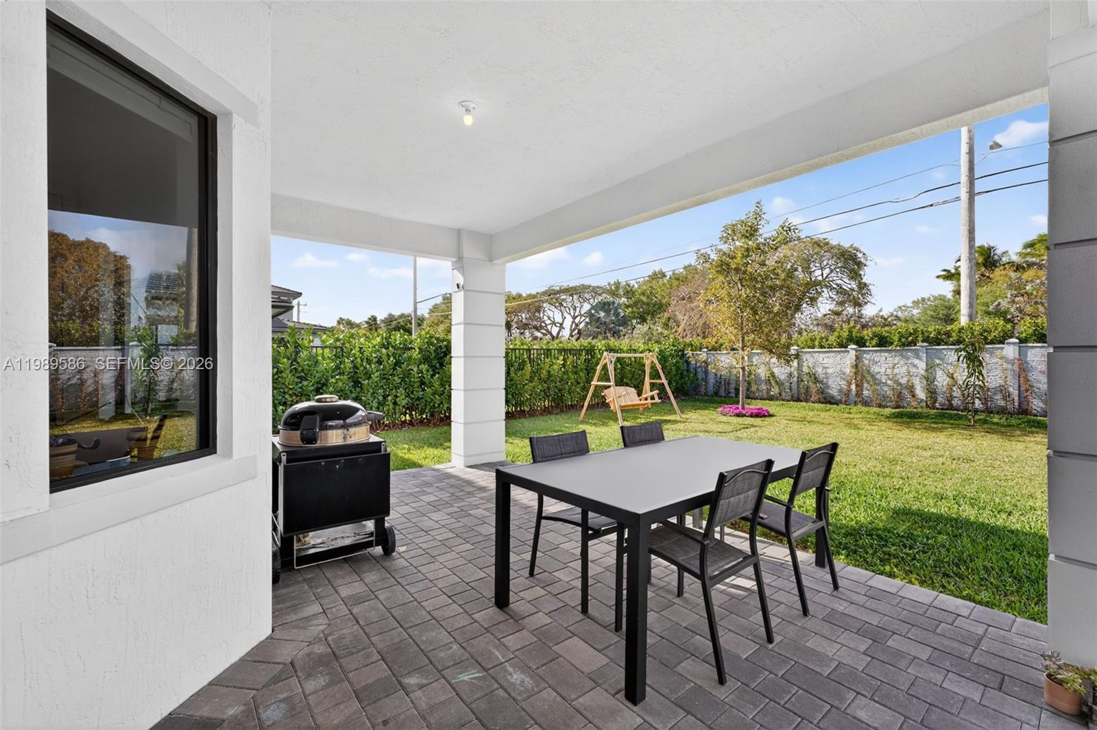 8267 Southwest 120th Terrace Miami, FL 33156 - Photo 42 of 61 a view of a patio with a table chairs and a backyard