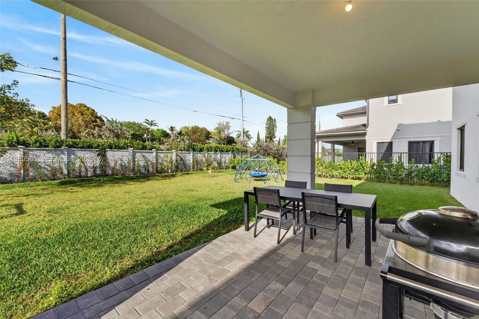 8267 Southwest 120th Terrace Miami, FL 33156 - Photo 43 of 61 a view of a patio with a table chairs and a garden