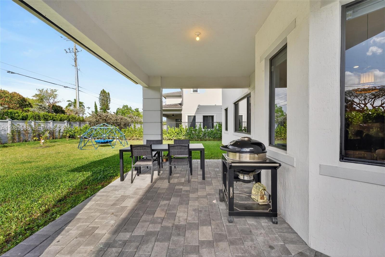 8267 Southwest 120th Terrace Miami, FL 33156 - Photo 44 of 61 a view of a patio with table and chairs potted plants and a palm tree