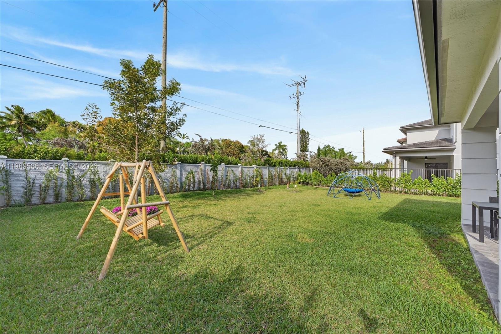 8267 Southwest 120th Terrace Miami, FL 33156 - Photo 46 of 61 a view of a backyard with a slide trees and wooden fence