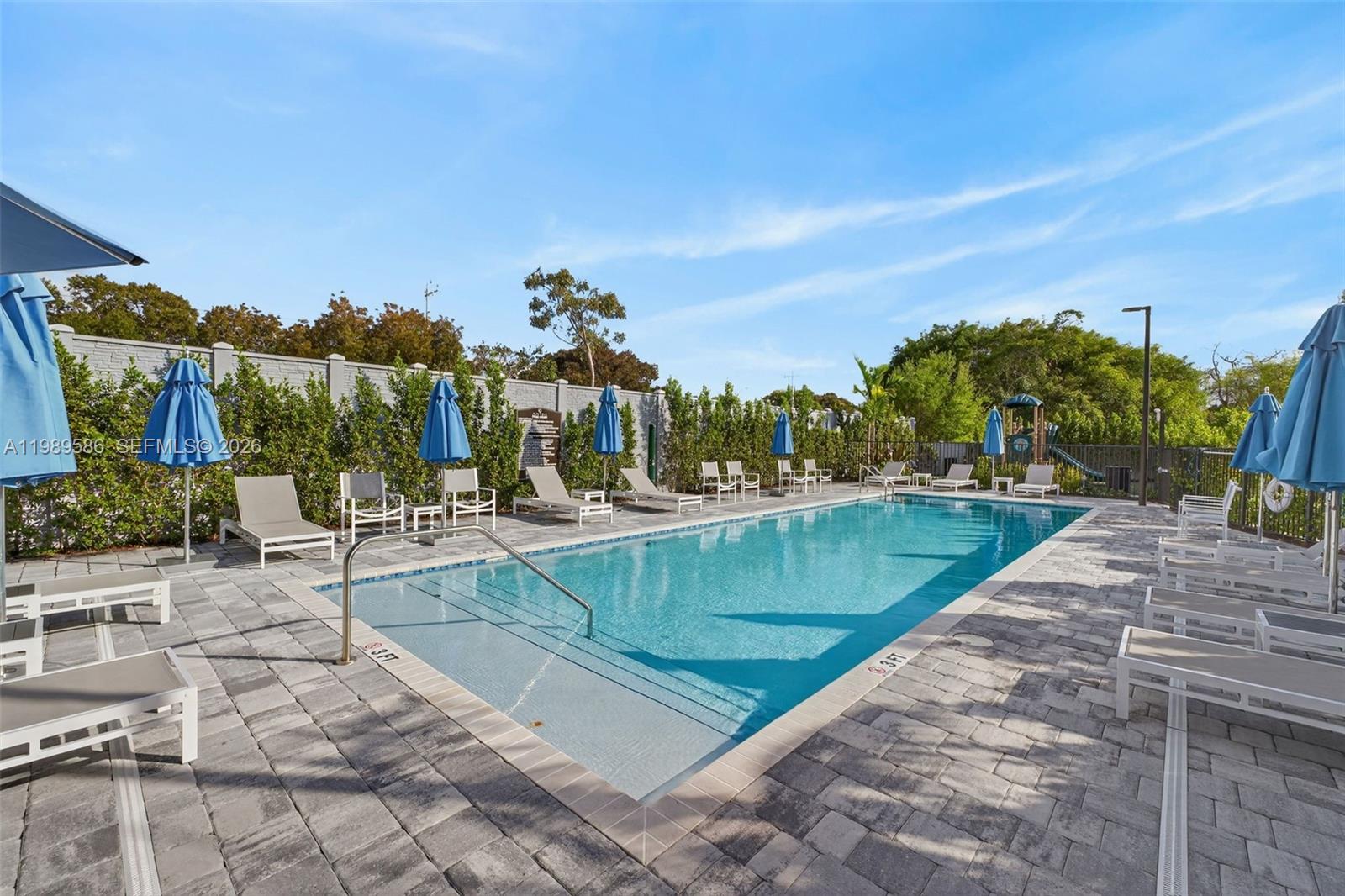 8267 Southwest 120th Terrace Miami, FL 33156 - Photo 57 of 61 a view of a swimming pool with a lounge chairs