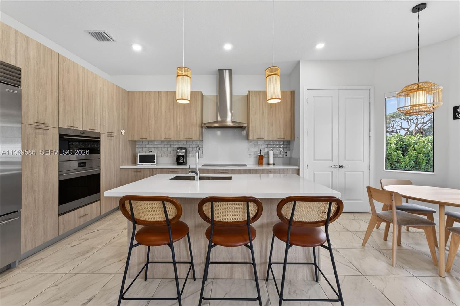 8267 Southwest 120th Terrace Miami, FL 33156 - Photo 8 of 61 a kitchen with stainless steel appliances granite countertop a stove a sink a microwave a island with a dining table and chair